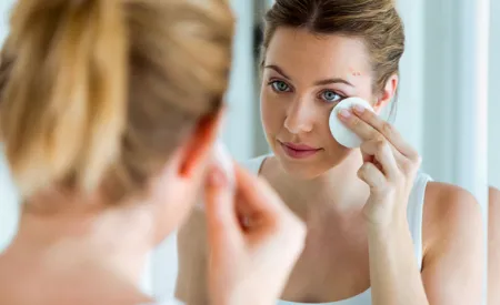 Woman with acne-prone skin cleaning her face